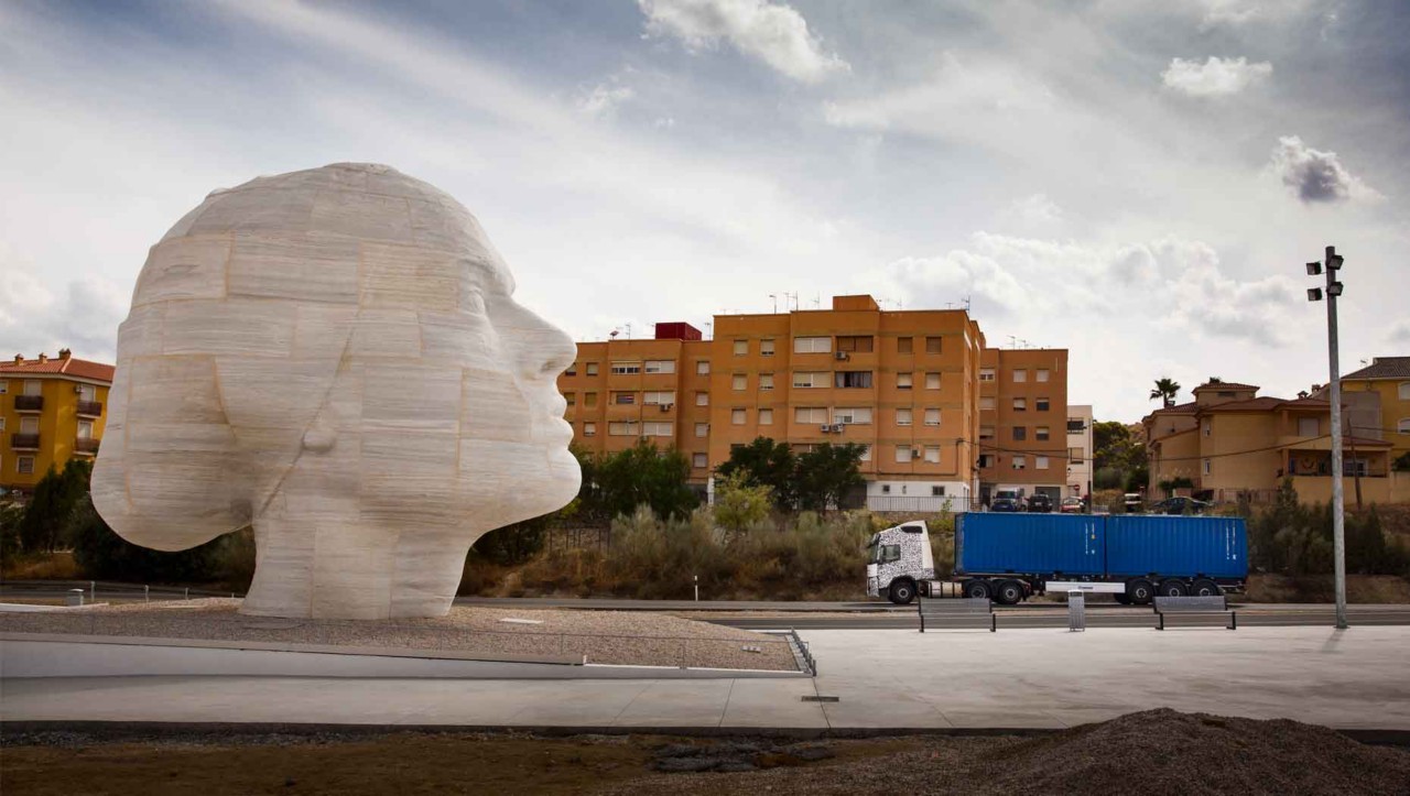 A test truck passes a marble statue in Spain